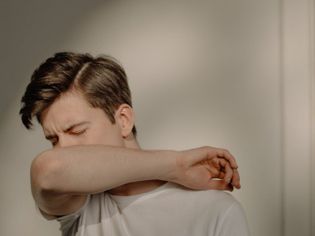 Un homme ayant le nez dans son coude