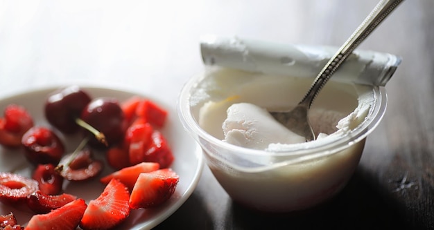 Fresh yogurt with berries Ice cream in a bowl with fresh and juicy strawberries and cherries Dessert with red berries