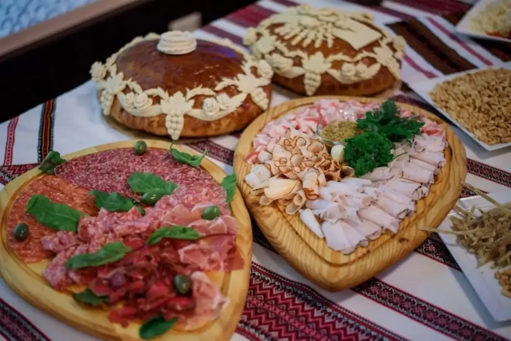 Wooden dishes with snacks stand on red embroidered tablecloth