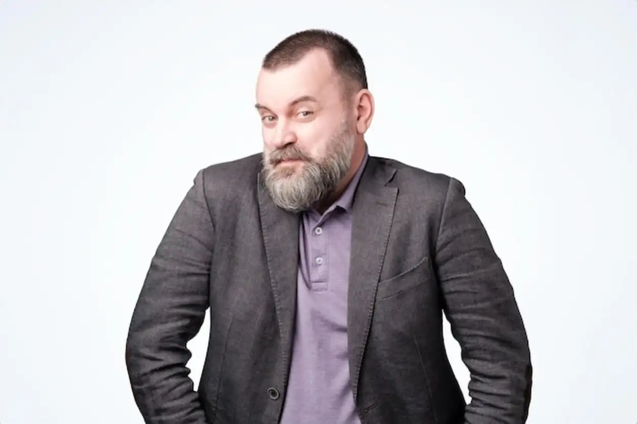 Cunning tricky mature man in jacket on white studio wall