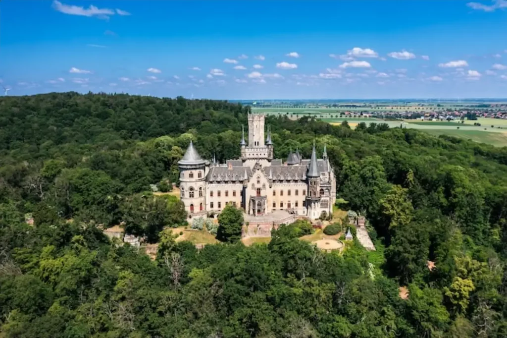 German castle Marienburg immersed in the greenery of the forest not far from Hannover Aerial view of a medieval romantic castle