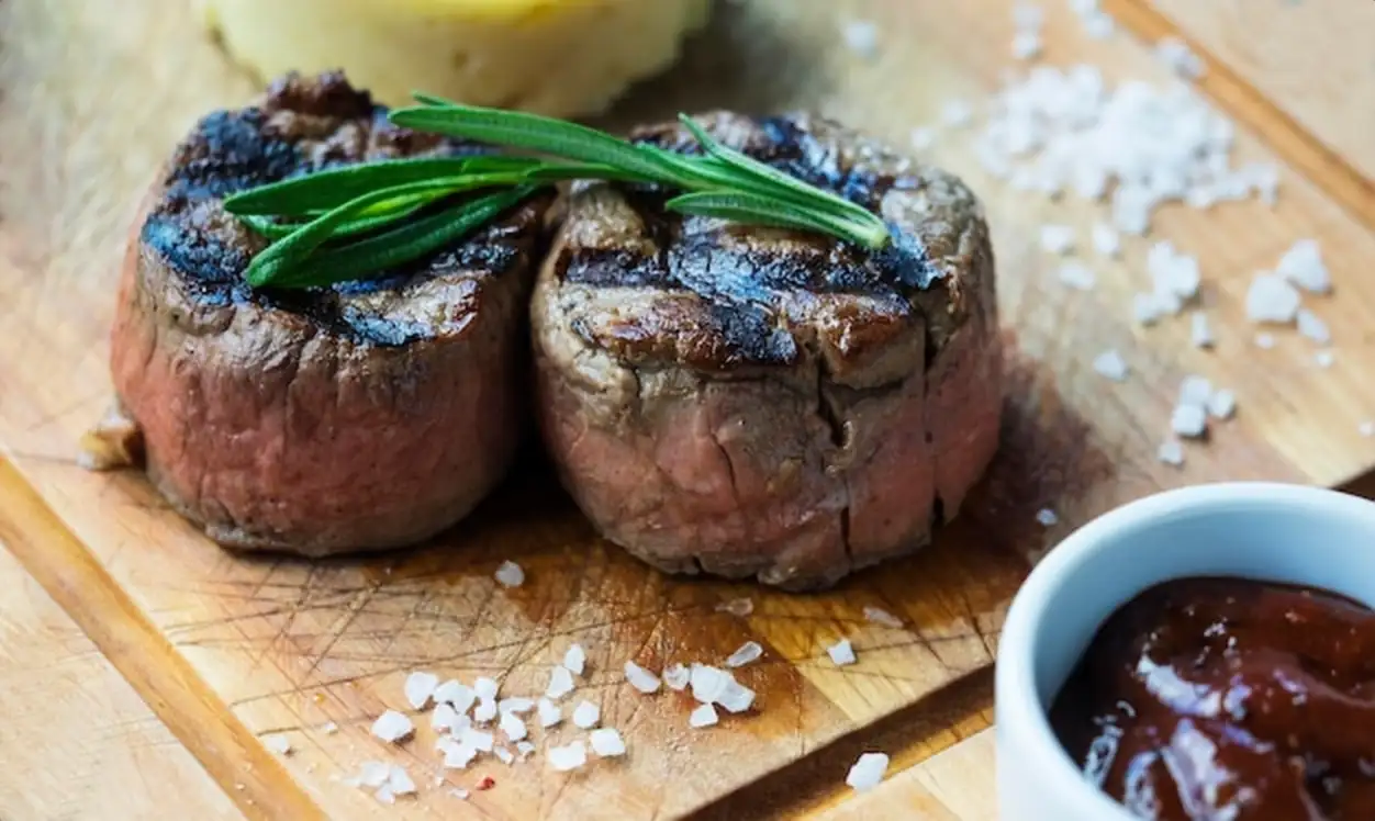 High angle view of fresh veal medallion on wooden cutting board