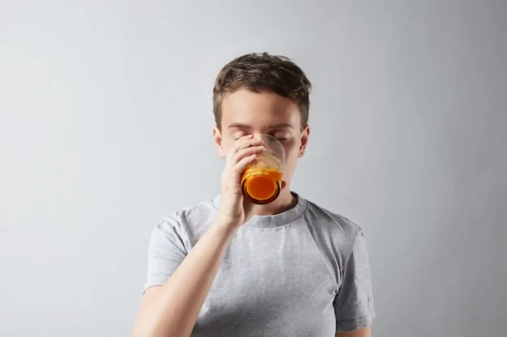 Young beautiful woman with healthly perfect skin dreamly drinking her fresh organic carrot orange juice