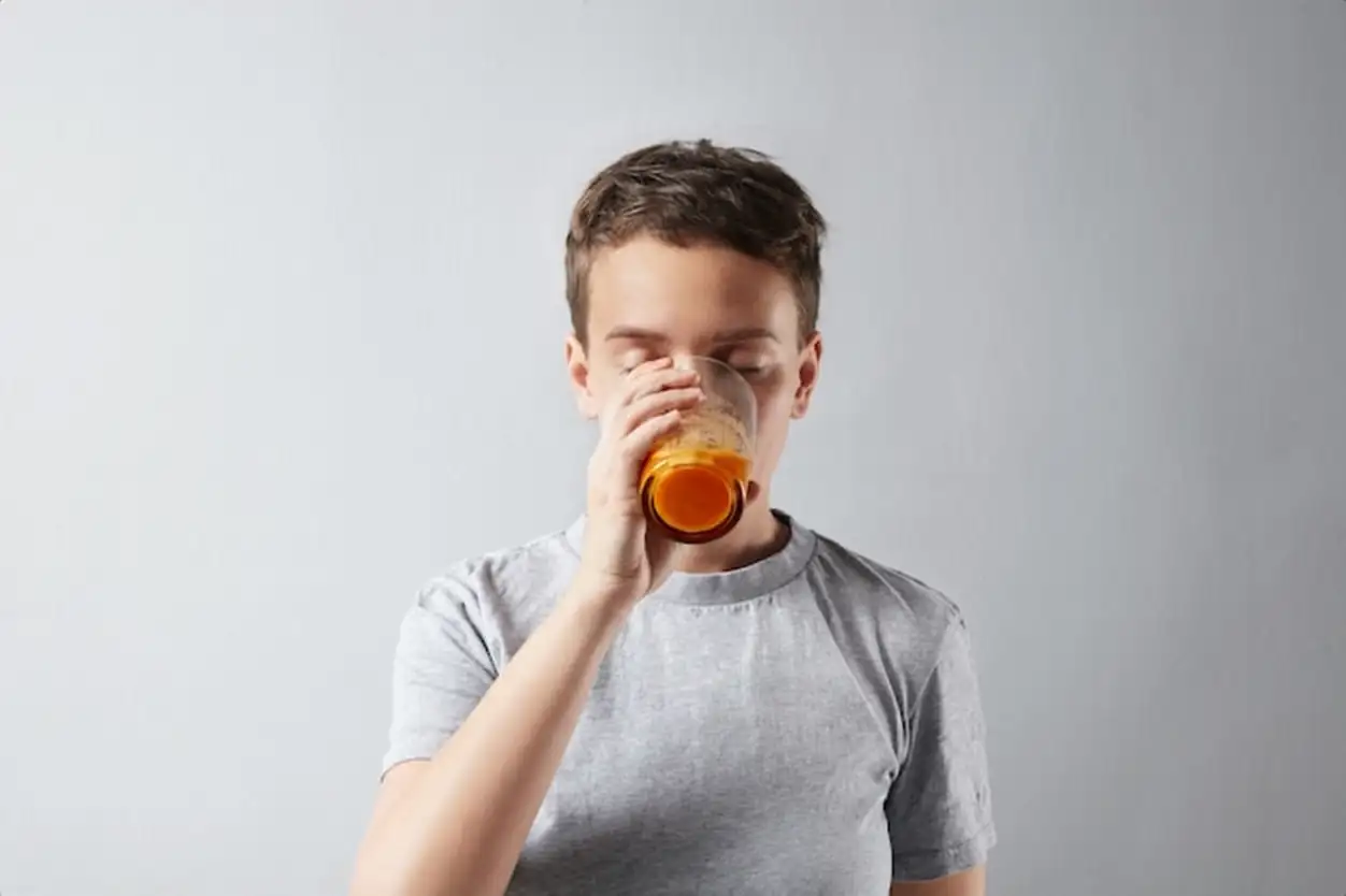 Young beautiful woman with healthly perfect skin dreamly drinking her fresh organic carrot orange juice