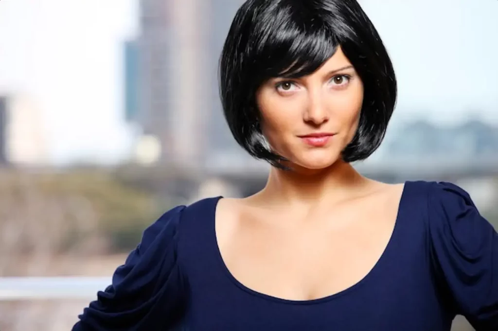 a young confident woman standing against light background