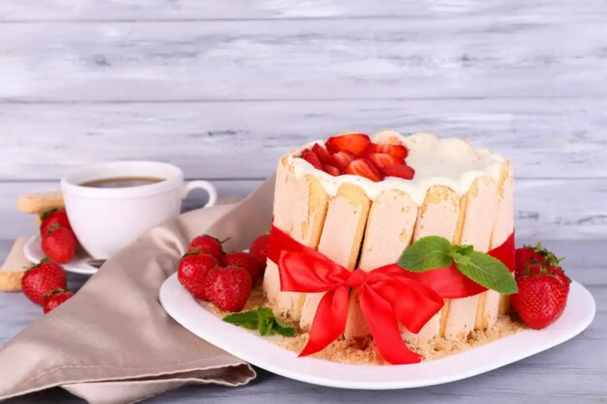 Tasty cake Charlotte with fresh strawberries on wooden table