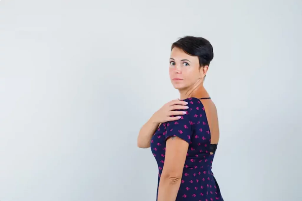Woman in dress looking over her shoulder and looking concerned .