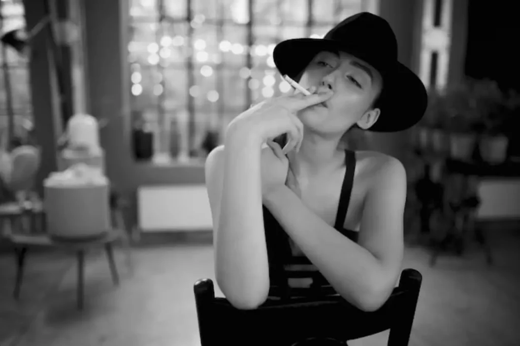 Smoking girl in elegant clothes and hat