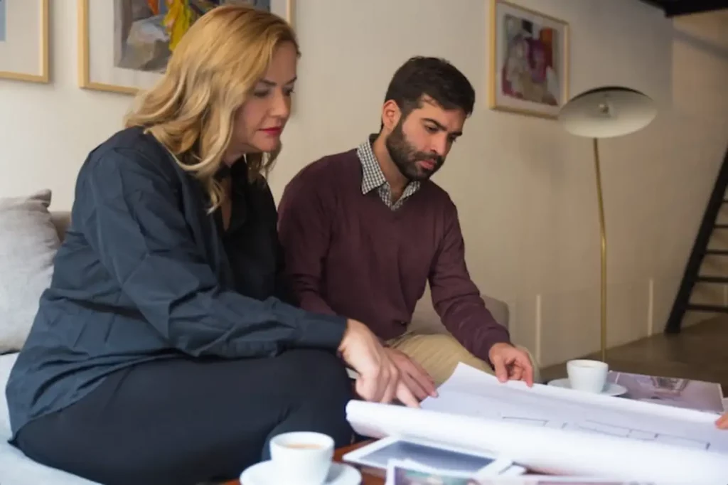 Interior designer and client studying blueprint
