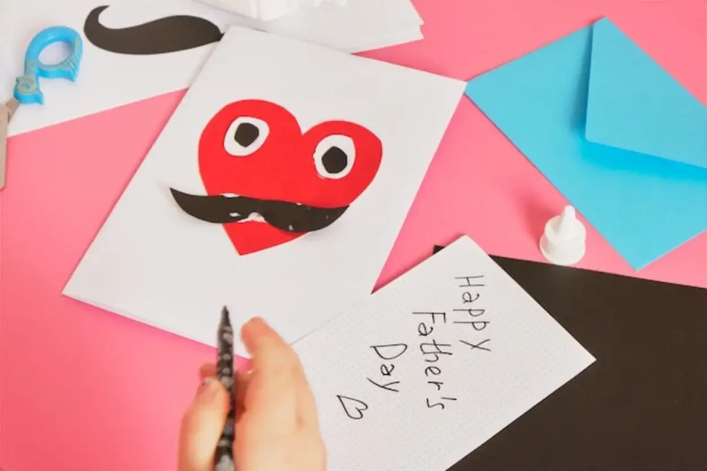 Child makes a card for father's day red paper heart with mustache card for dad step by step instructions