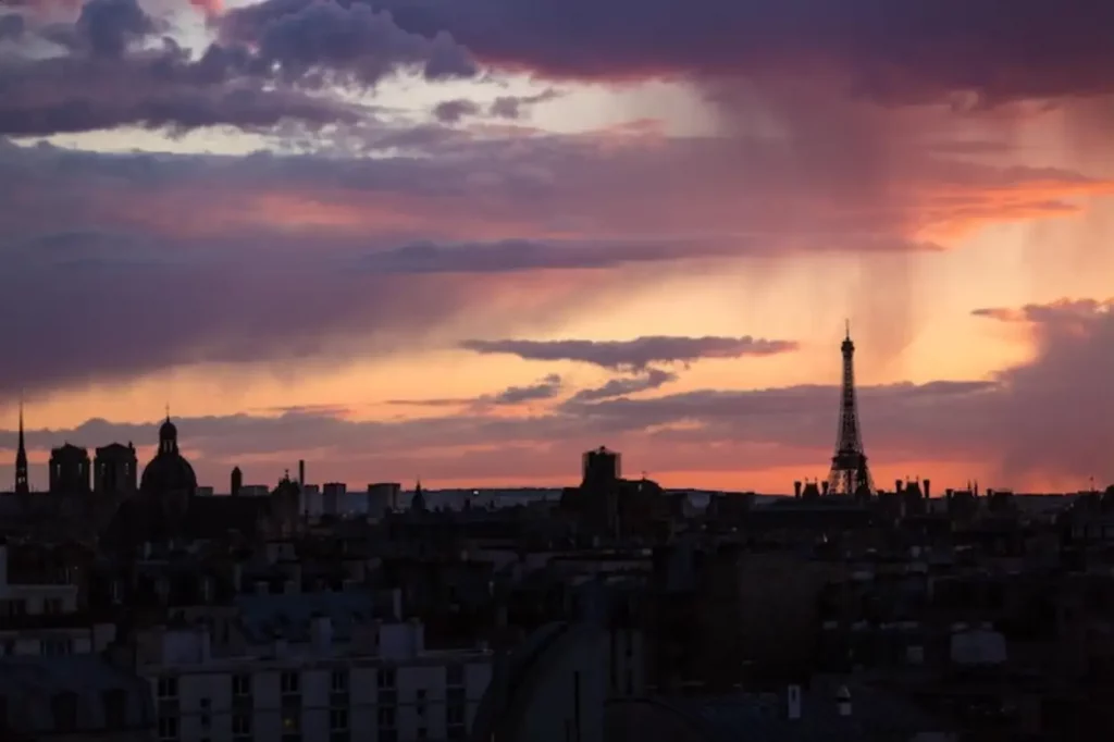 Cityscape against cloudy sky at sunset