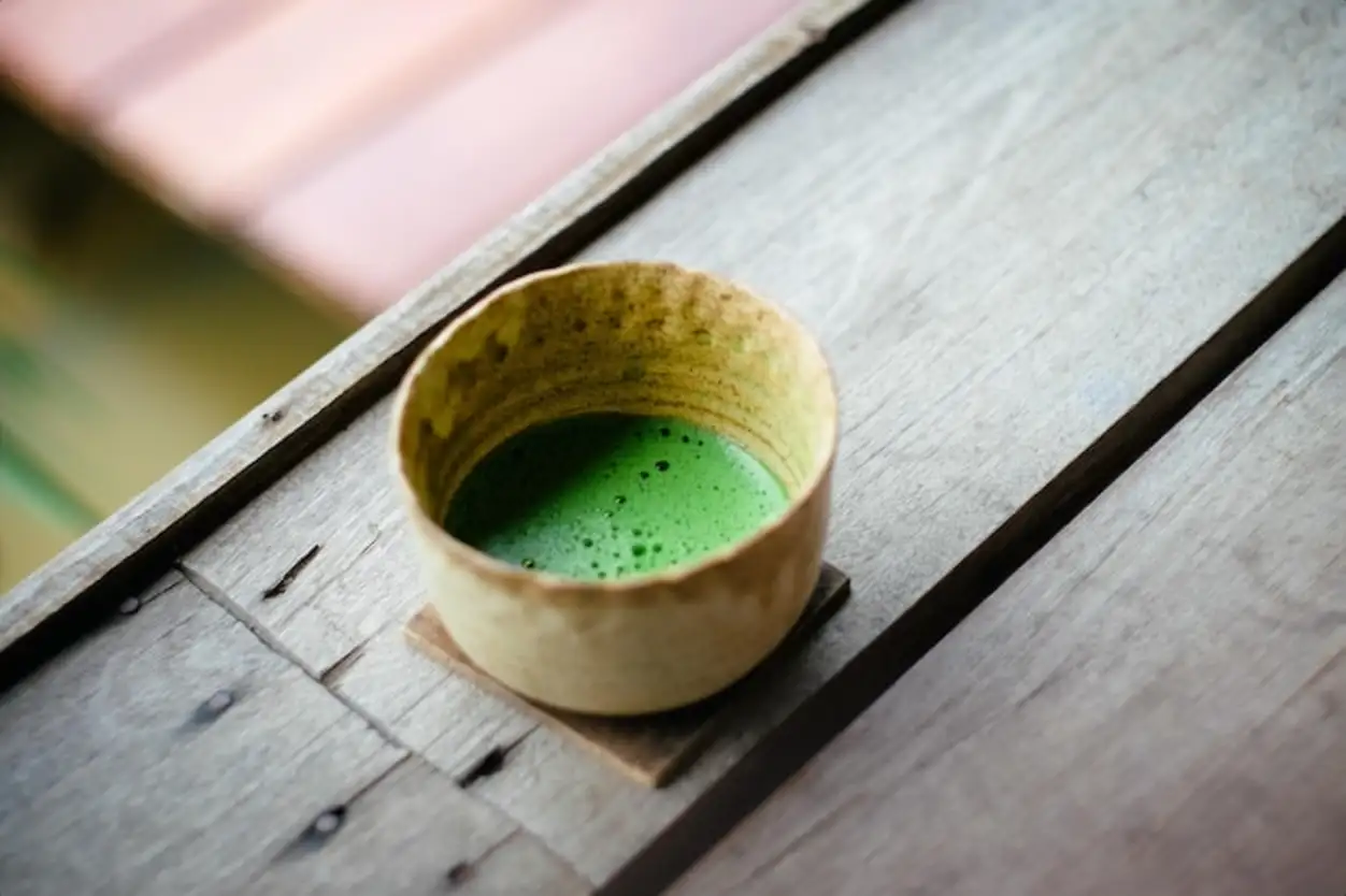 High angle view of matcha tea on cup on wooden table