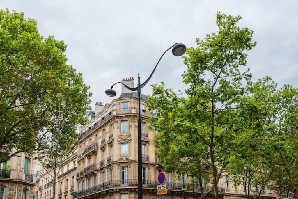 Low angle view of street light by building against sky