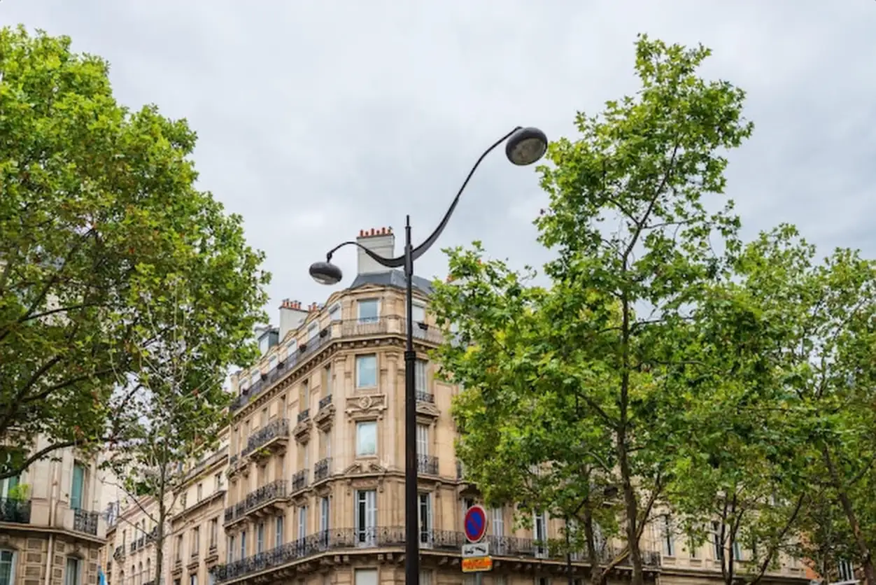 Low angle view of street light by building against sky