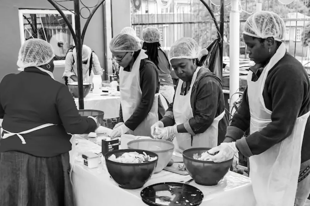Soup Kitchen community outreach volunteers preparing meals for African children at orphanage