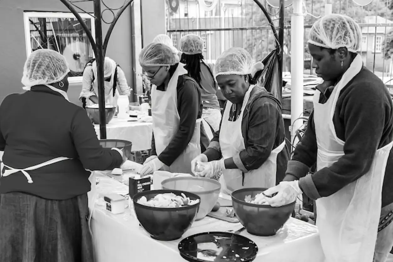 Soup Kitchen community outreach volunteers preparing meals for African children at orphanage