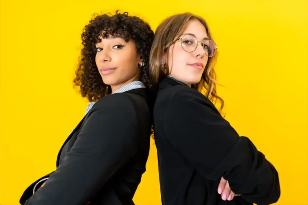 businesswomen back to back with crossed arms looking at camera
