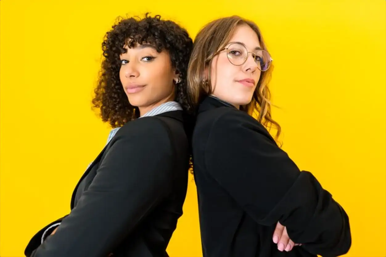 businesswomen back to back with crossed arms looking at camera