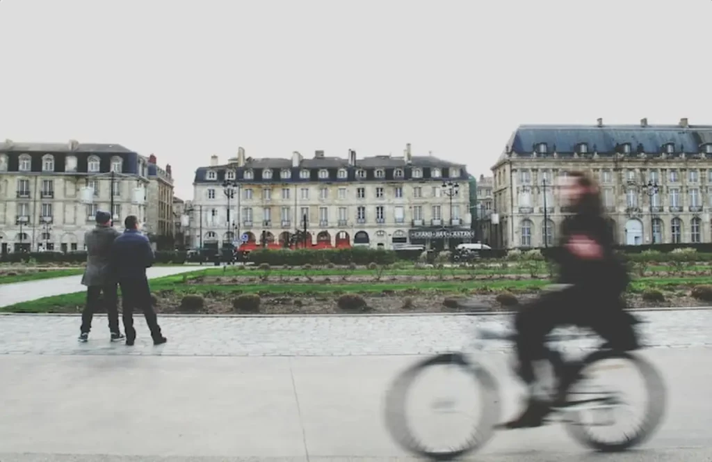 Blurred motion of man riding bicycle on city street