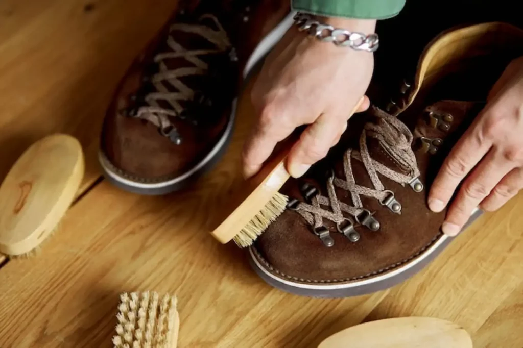 Man's hand cleans suede shoes with brush