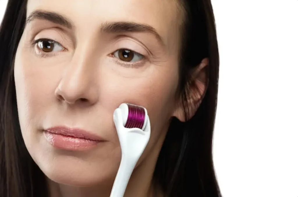 Anti aging treatment. Middle aged woman using mesoroller for her facial skin.