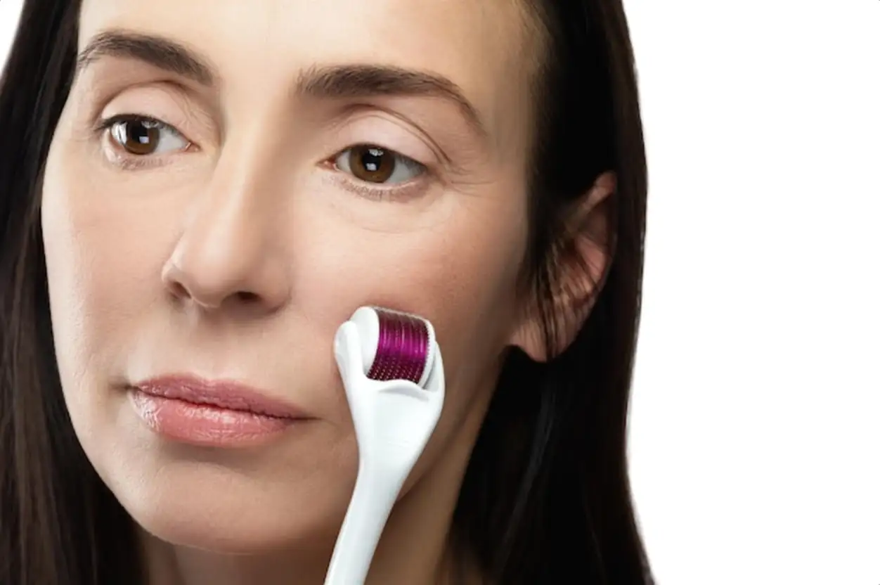 Anti aging treatment. Middle aged woman using mesoroller for her facial skin.