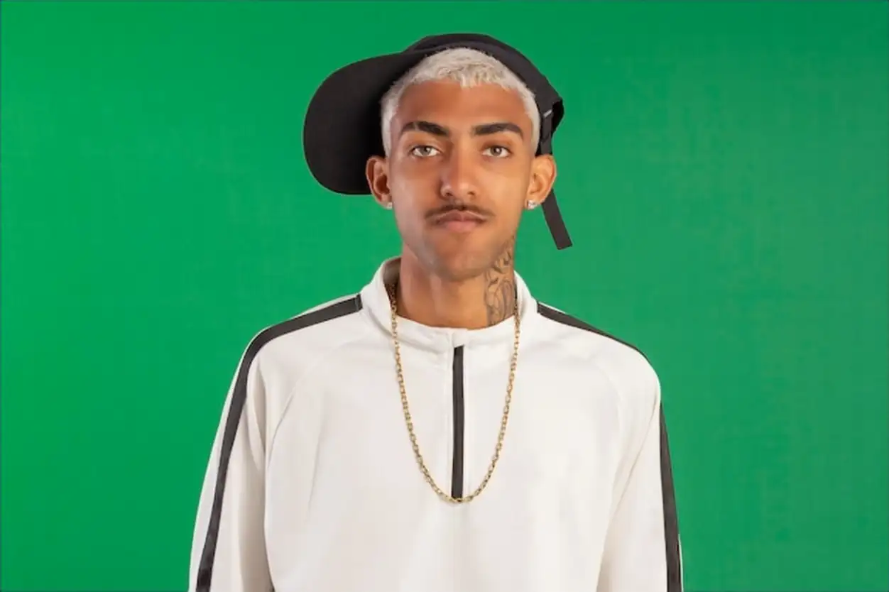 Young adult from the periphery with 'pivete blonde' hair in studio photo with green background