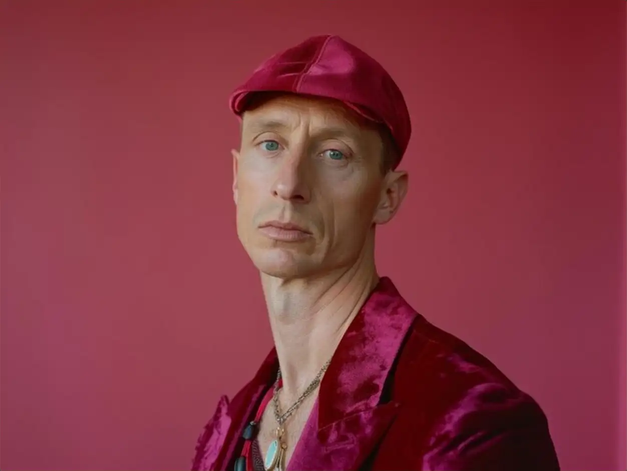 Medium shot of candid fashion portrait of a man short hair in a bright velvet baseball cap velvet