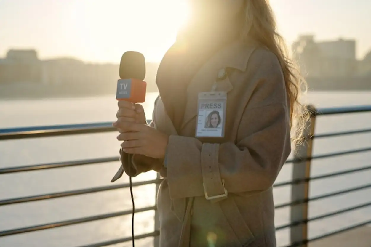 Young female reporter with microphone
