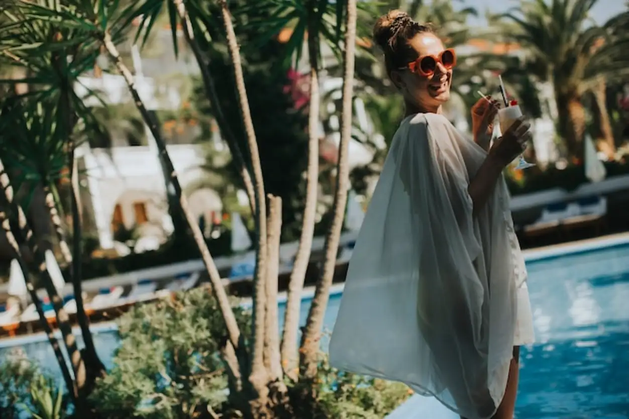 Young woman standing next to the pool