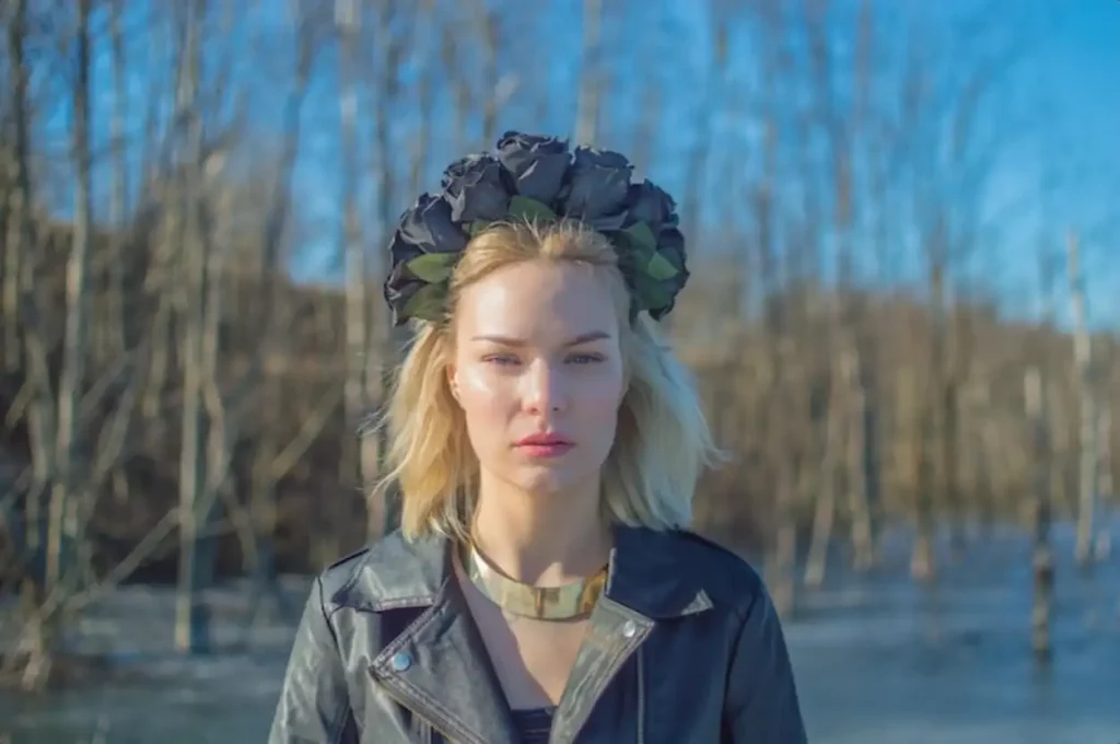 The girl in the black wreath of flowers looking at the camera.