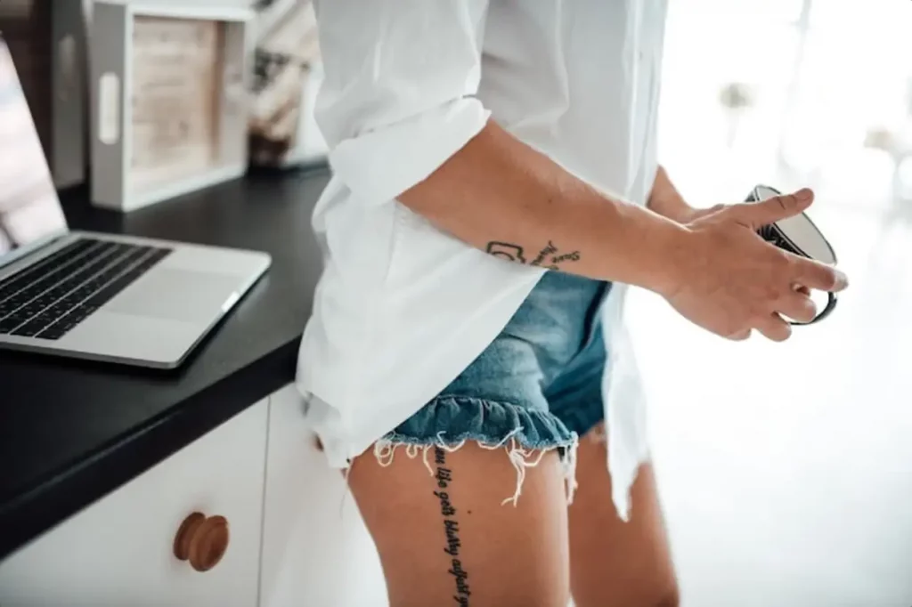 Midsection of woman holding cup standing at home