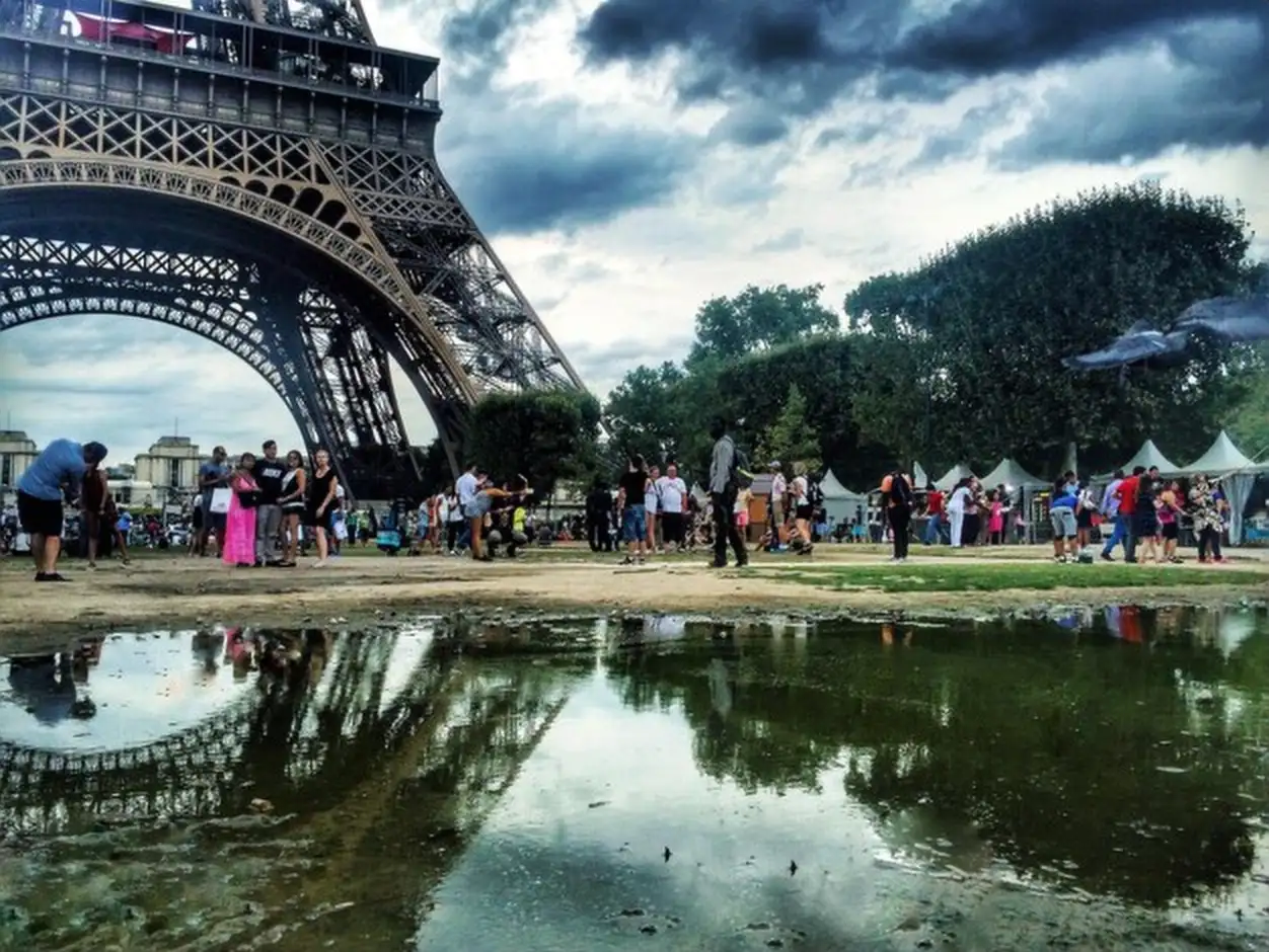 People at eiffel tower against sky in city
