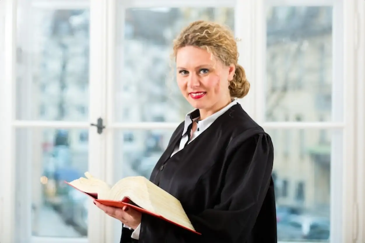 Young female lawyer working in her office reading in a typical law book