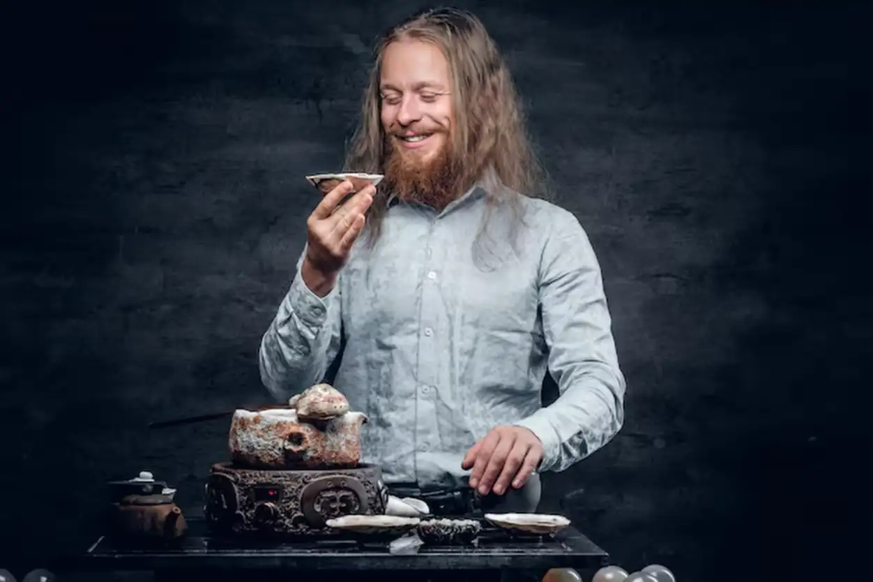 Positive bearded male tasting tea in Chinese style.
